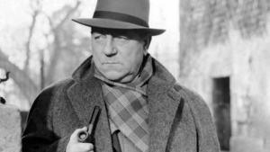 Jean Gabin as Maigret looks around corner