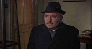 James Mason as Dobbs sits in confusion