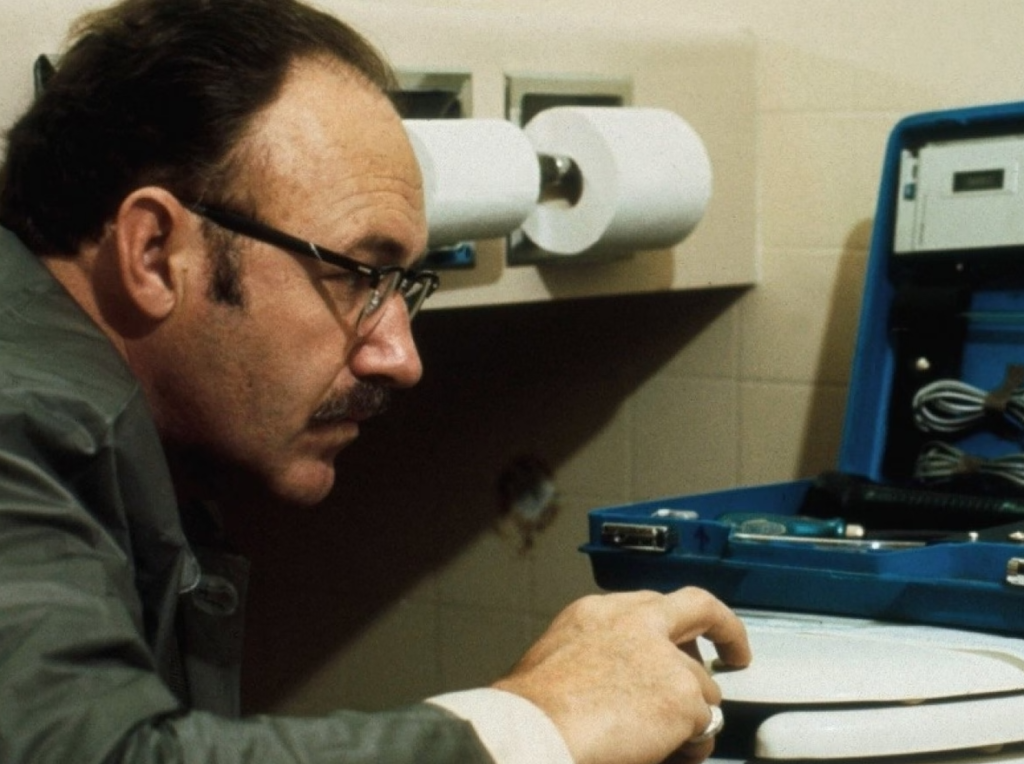 A sound technician prepares a listening device in a bathroom.
