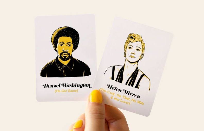 A hand with yellow-painted fingernails is holding two cards, one with a drawing of Denzel Washington and another of Helen Mirren