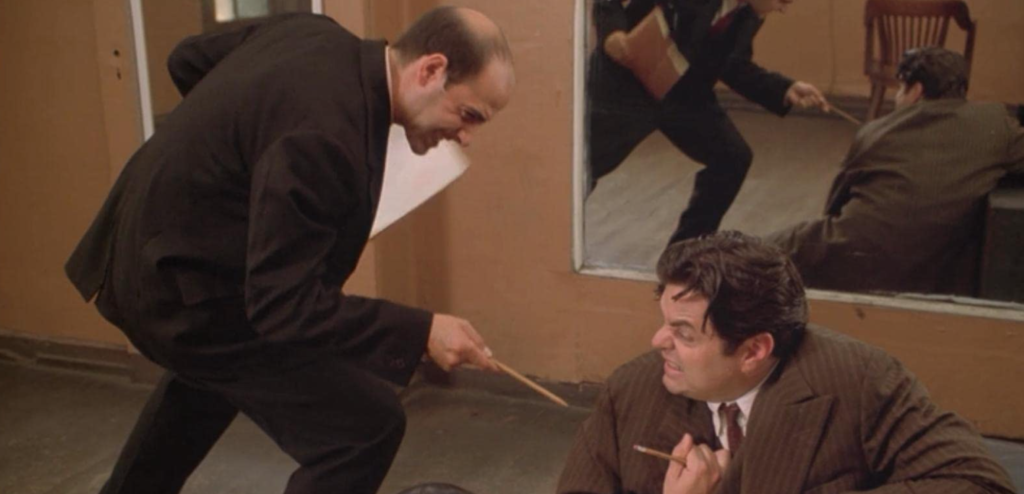 Two actors read a script and enact a sword fight using pencils