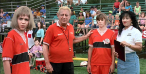 Two soccer coach coach their players at a game