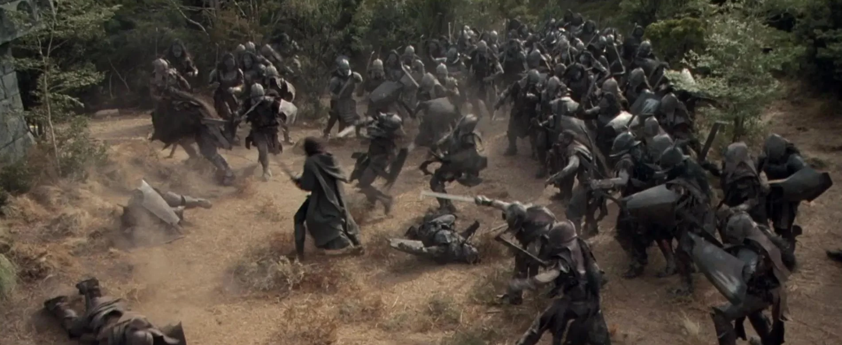 Aragorn uses his sword to defend himself against a whole army of orcs